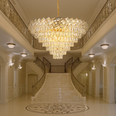 Candelabru rotund din cristal auriu Ø800 mm, cu 16 surse E27, montat intr-un living inalt pentru efect regal si luminos