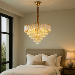 Candelabru rotund auriu cu panouri albe și cristale, luminând elegant un dormitor modern și spațios cu atmosferă rafinată.