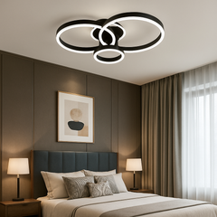 Lustra LED cu 3 cercuri negre si telecomanda, instalata in dormitor modern, oferind luminare uniforma si o atmosfera eleganta si calma.