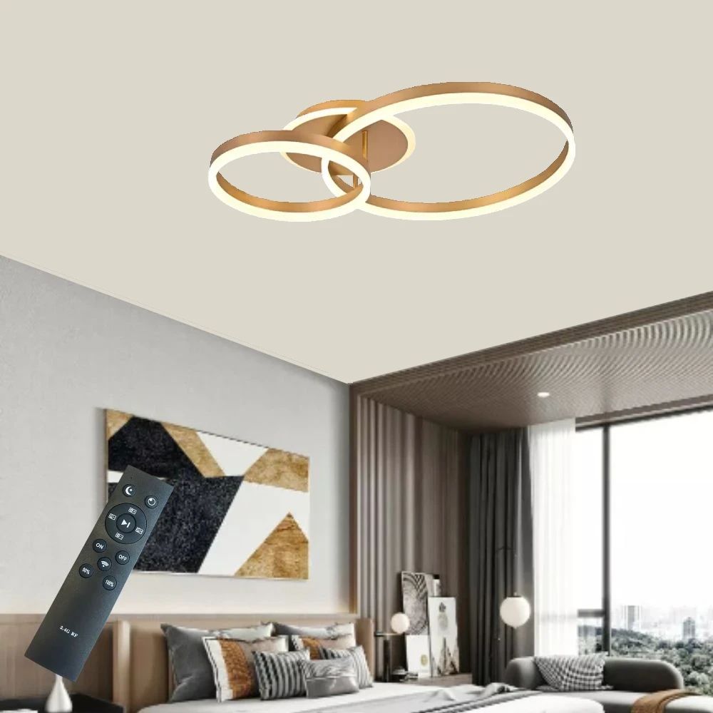 Lustra LED cu doua inele aurii si telecomanda, montata in living modern, oferind luminare eleganta si un stil decorativ contemporan.