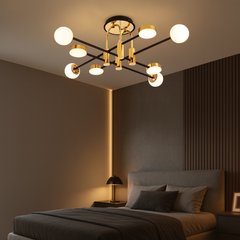 Lustra LED cu brate aurii si globuri opal, instalata in dormitor modern, lumină reglabila 3000K–6500K cu telecomanda.