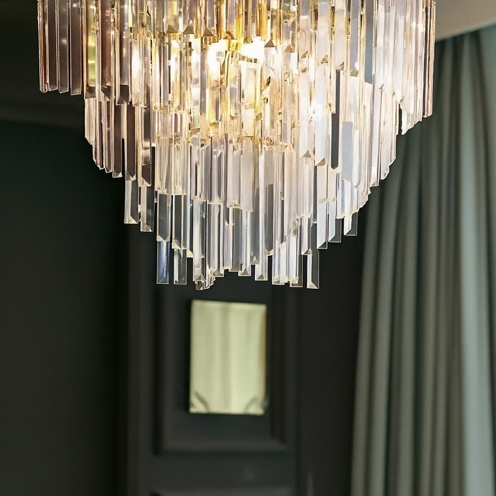 Candelabru auriu modern cu 5 surse E27 si elemente transparente creeaza in dormitor o lumina ambientala eleganta si relaxanta.