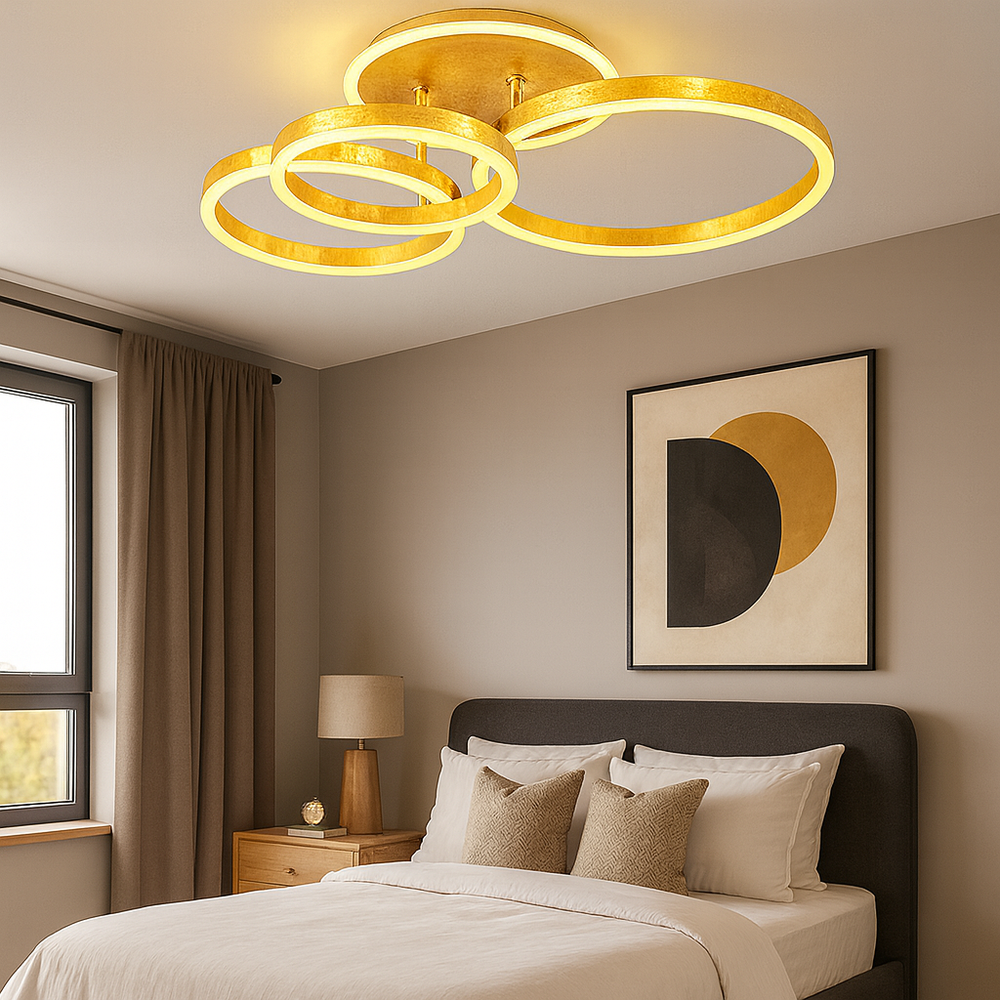Lustra LED cu 3 cercuri aurii si telecomanda, instalata in dormitor modern, oferind luminare uniforma si o atmosfera calda si eleganta.
