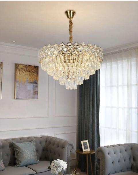 Candelabru rotund din cristal auriu Ø500 mm, montat central intr-un living elegant cu iluminare intensa si reflexii luxoase